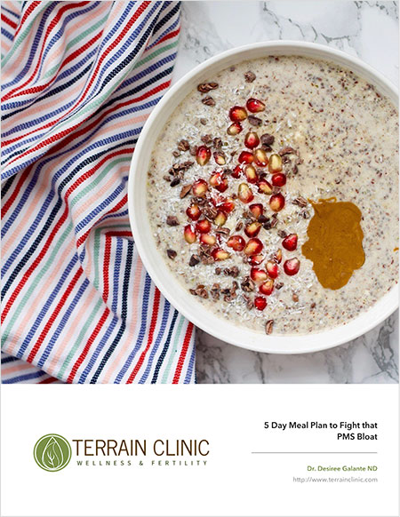 Healthy breakfast: oats, nuts, honey, pomegranate on a marble counter next to a colorful dish towel