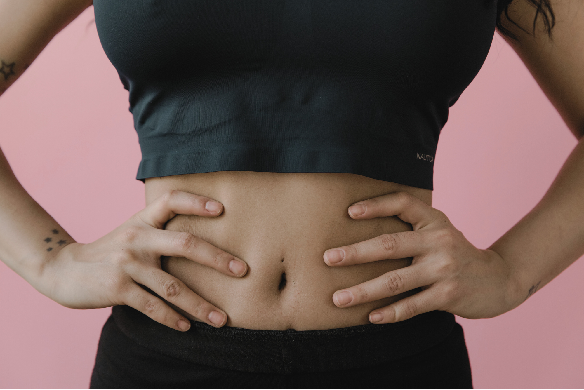 Woman holding her stomach, symbolizing gut discomfort or gut health issues related to autoimmune conditions.